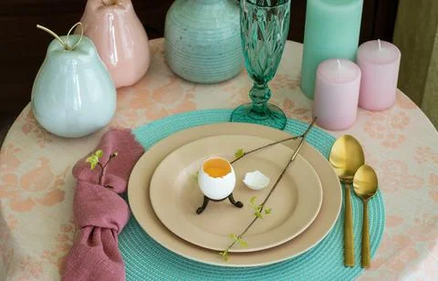Spring table set for Easter - a chicken egg and a twig with the first leaves on Stock Photos
