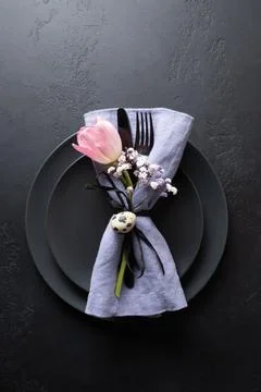 Spring table setting with flower tulips decor on black. Easter dinner. Stock Photos