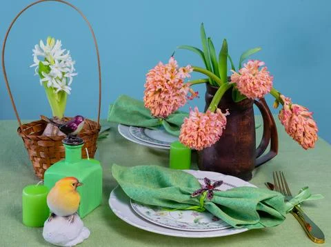 Spring table setting with hyacinths on a green linen tablecloth Stock Photos