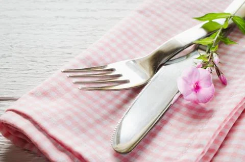 Spring table settings with fresh flower, napkin and silverware. Stock Photos