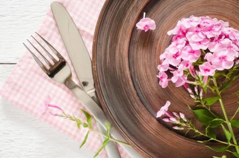 Spring table settings with fresh flower, napkin and silverware. Stock Photos