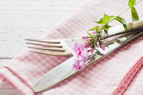 Spring table settings with fresh flower, napkin and silverware. Stock Photos