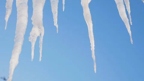 Spring thaw, ice icicles on blue sky background Stock Footage 101774261