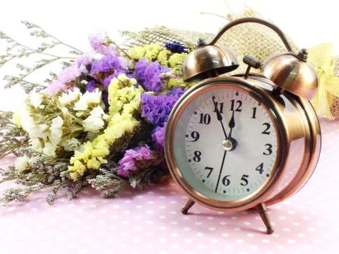Spring time with alarm clock and statice flowers bouquet background 스톡 사진