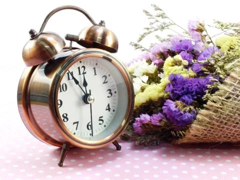 Spring time with alarm clock and statice flowers bouquet background 스톡 사진