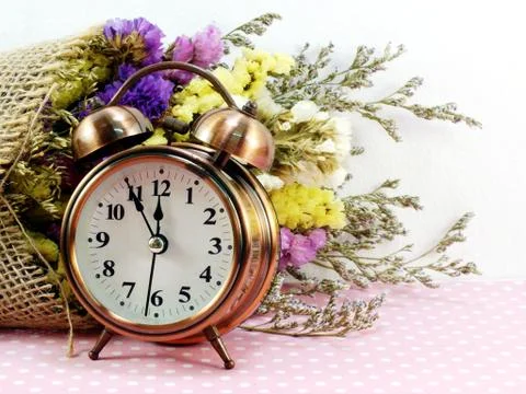 Spring time with alarm clock and statice flowers bouquet background Stockfoto's
