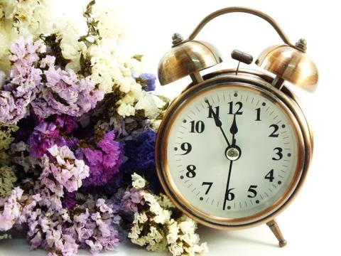 Spring time with alarm clock and statice flowers bouquet background Foto stock