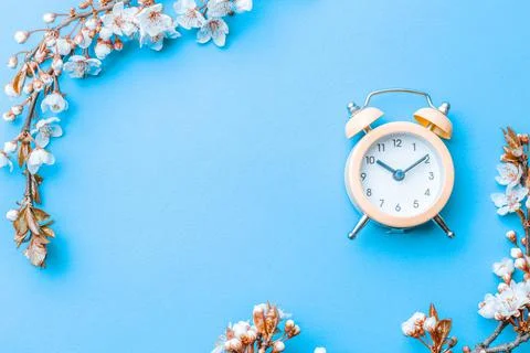 Spring time background. May flowers and April floral nature with alarm clock  Stock Photos