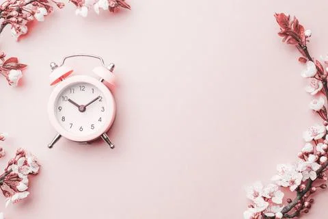Spring time background. May flowers and April floral nature with alarm clock  Stock Photos