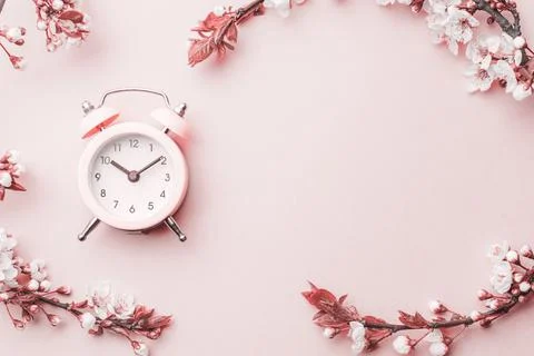 Spring time background. May flowers and April floral nature with alarm clock on Stock Photos