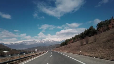 Spring time highway drive trip with view of mountain range peaks covered with Video stock 250005876