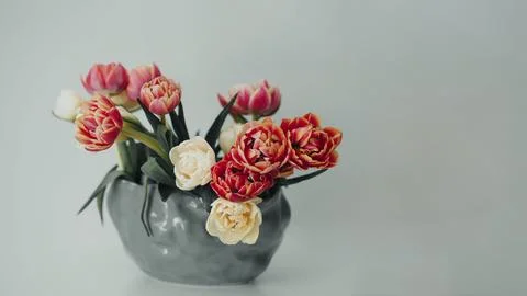 Spring tulips in a vase on a grey table. Mock up for displaying works Stock Photos