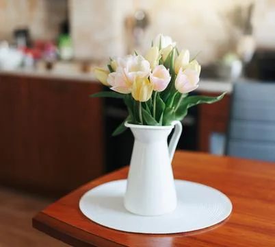 Spring tulips in a vase on the table. Spring holiday, home decor. Stock Photos