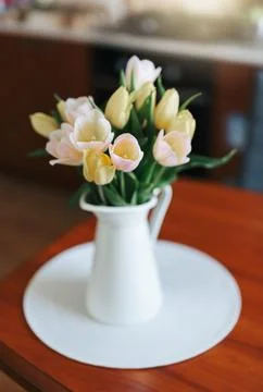 Spring tulips in a vase on the table. Spring holiday, home decor. Stock Photos