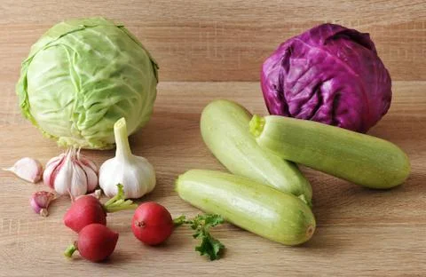 Spring vegetable set - whole heads of cabbage, zucchini, radish and garlic Stock Photos