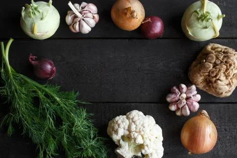 Spring vegetables on a dark background: cauliflower, onion, garlic, kohlrabi Stock Photos