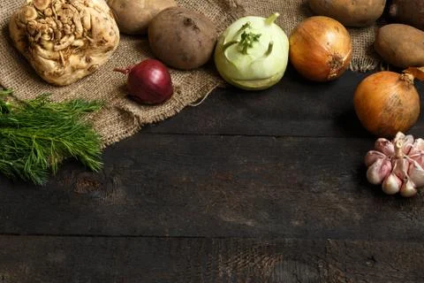Spring vegetables on a dark background: onion, garlic, kohlrabi, celery root Stock Photos