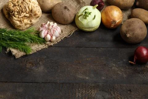 Spring vegetables on a dark background: onion, garlic, kohlrabi, celery root Stock Photos
