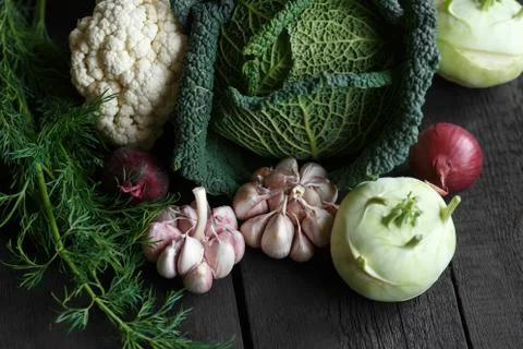 Spring vegetables on a dark background: Savoy cabbage, cauliflower, onion Stock Photos