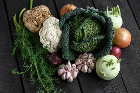 Spring vegetables on a dark background: Savoy cabbage, cauliflower, onion Stock Photos