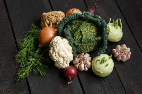 Spring vegetables on a dark background: Savoy cabbage, cauliflower, onion Stock Photos