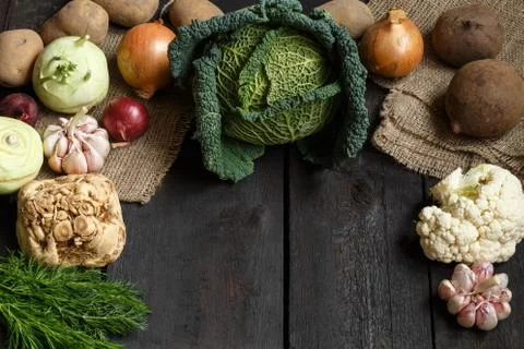 Spring vegetables on a dark background: Savoy cabbage, cauliflower, onion Stock Photos
