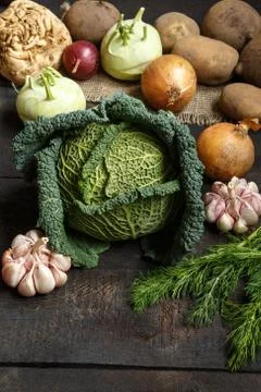 Spring vegetables on a dark background: Savoy cabbage, cauliflower, onion Stock Photos