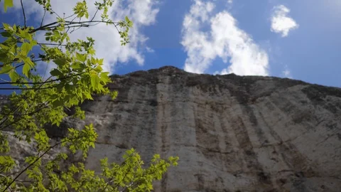 Spring. View of the cliffs. The young leaves on the tree. Blue sky with clouds 스톡 동영상 129247571