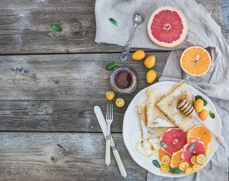 Spring vitamin breakfast set. Thin crepes or pancakes with fresh grapefruit,  Stock Photos