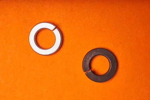 Spring washers on orange background. Bolted connection elements Stock Photos