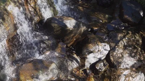 Spring water flowing down river with small waterfalls in slow motion Stock Footage 128431239