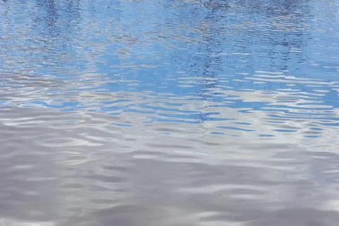 Spring water texture reflection of clouds and trees Fotos de archivo