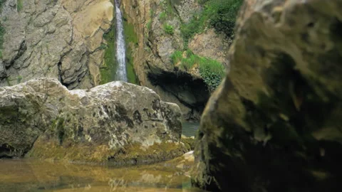 Spring waterfall among mountain rocks. In spring, snow melts intensively in the Video stock 225080773