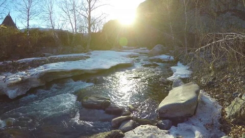 Spring waters in the stream, the snow lies in the valley, the sun is shining Stock Footage 82990223