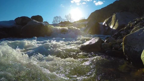 Spring waters in the stream, the snow lies in the valley, the sun is shining Stock Footage 109584869