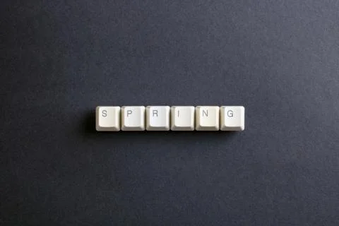 Spring word is written with computer keys button on a dark background. Foto stock