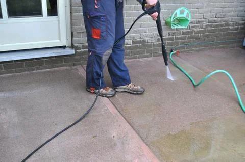 Spring yard work - man cleaning a sidewalk with a pressure washer Stock Photos
