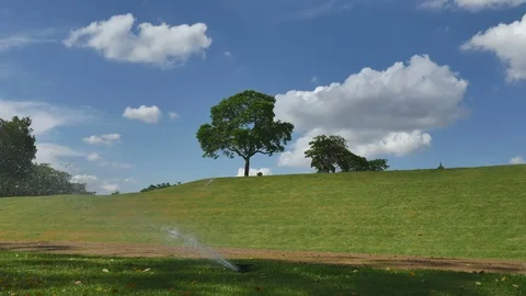 Springer watering the grass around Stock Footage 76443258
