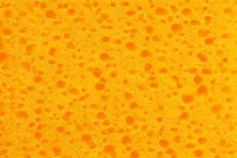 Springy texture of a sponge or foamy orange material Stock Photos