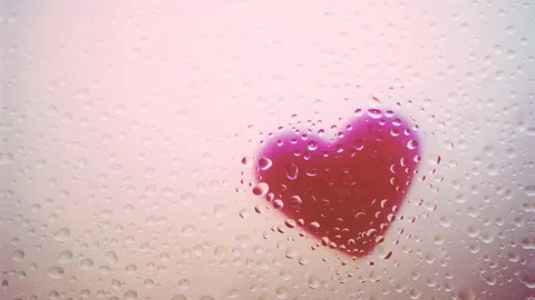 Sprinking Rain with Mist and Drops of Water on Glass. Heart in the Background. Stock Footage 131047342