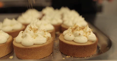 Sprinkle and decorate mini tarts with grated nuts. Stock Footage 252425407