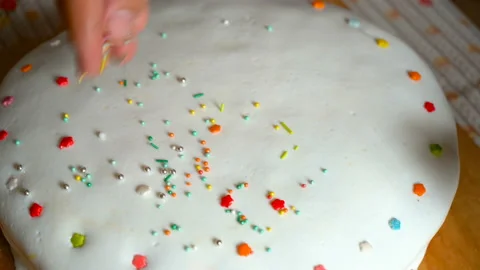 To sprinkle Colorful Sprinkles On to Cake Stock Footage 117776532