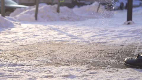 Sprinkle de-icing reagent to the ice in winter slow mo Stock Footage 100877205