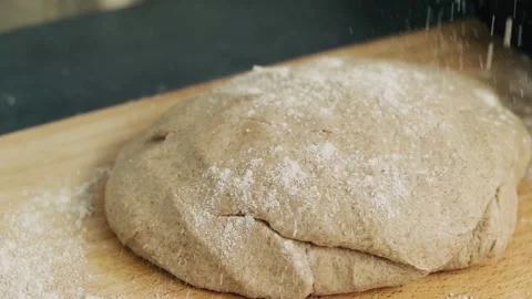 Sprinkle flour on the round large piece of dough. Making and preparing pastry Stock Footage 136181871