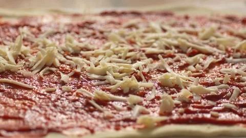 Sprinkle the grated cheese over the pizza. Stock Footage 266013749