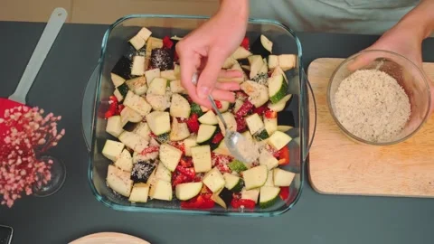 Sprinkle grated Parmesan with garlic and salt on top of the chopped vegetables Stock Footage 249288909