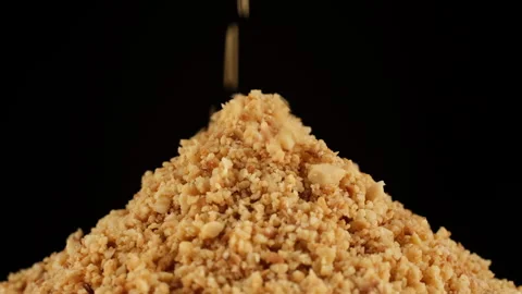 Sprinkle ground roasted hazelnuts close up, black background Video stock 250307560
