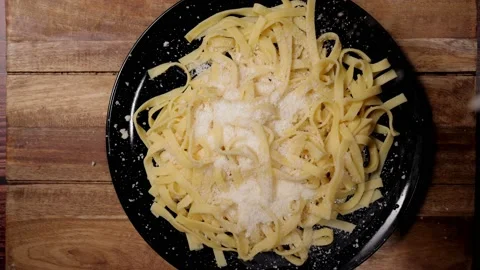 Sprinkle Parmesan cheese over a plate of pasta - slow motion 库存影片 151213841