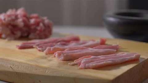 Sprinkle raw bacon with pepper and salt Stock Footage 111272833