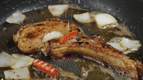 Sprinkle salt and black pepper over fried pork chops. Stock Footage 178237871